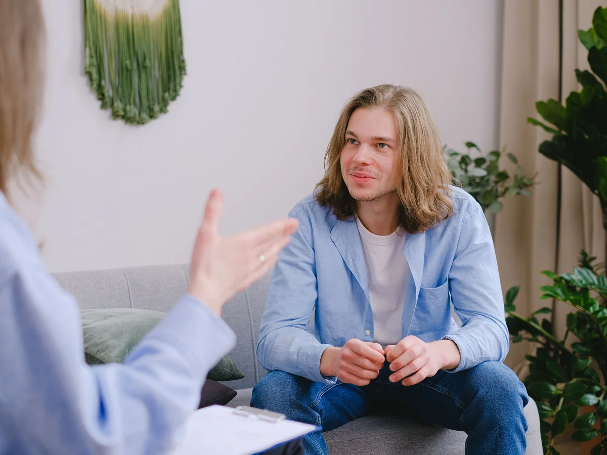 A man talks with a counselor during a seated conversation.