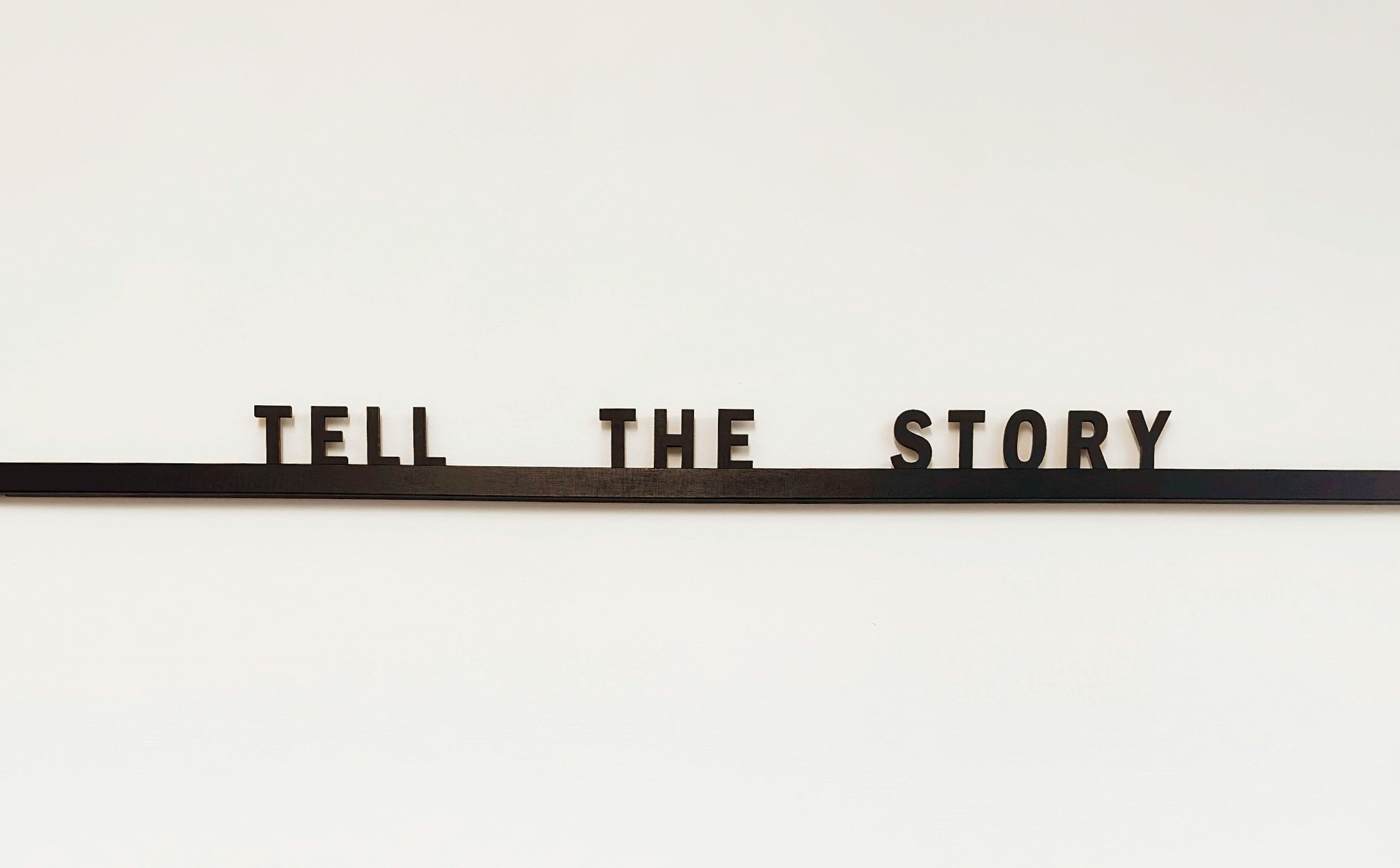 Letter tiles spelling "Tell the story" on a ledge